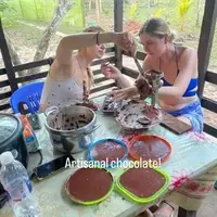 Two volunteers at Semillas Life NGO performing the final stages of artisanal chocolate making in Codo del Pozuzo, Peru. They are refining local, sustainably sourced cacao as part of a community-based economic development workshop in the Amazon.