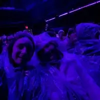 A mentor and mentee are pictured in a dark room with blue lighting, covered in fake cobwebs, smiling.