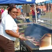 Volunteer grilling food during our Mud Volleyball event