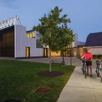 A pair of cyclists standing outside of a museum building