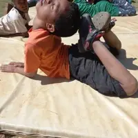 young boy stretching his feet to his head