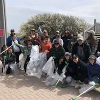 group of people pose at a beach cleanup