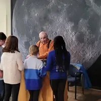 Volunteer running a science activity for a group.