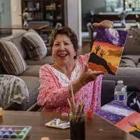Senior holding up painting