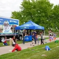 An outdoor scene shows kids playing with a variety of equipment including giant jenga, pogo sticks, jump ropes, and hula hoops.