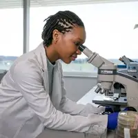 Graduate student looking through microscope