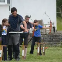 Young people being instructed on Archery