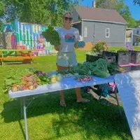 City Fresh volunteer standing at a Fresh Stop behind a table full of fresh produce