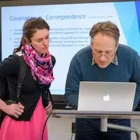 Graduate student and professor looking at laptop