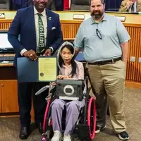 Amy and the mayor holding the proclamation that signed by the Mayor for City of Denton