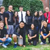 Group of ASPIRE students and mentors posing with matching black shirts