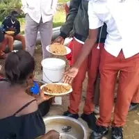 Ugandan students enjoying a meal with their teacher after a mentorship camp. This shows TNYME Uganda’s support for disadvantaged children. Volunteers can help set up and manage our GoFundMe to build a permanent school.