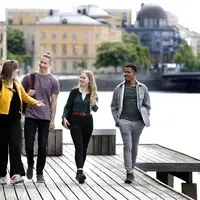 Students walking along the Clear River in the city center