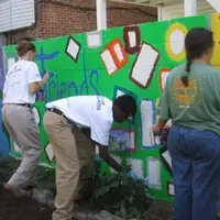 Volunteers painting a mural in an alleyway