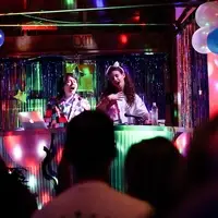 Two performers singing in a 90s prom themed event