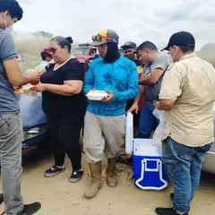 Minadores de basura recibiendo pasta con bolognesa de manos de voluntarios en Venezuela
