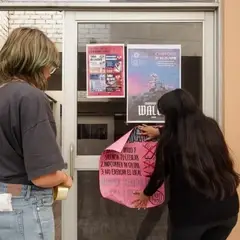 Mujeres pegando carteles en una puerta