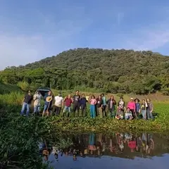 Grupo de personas voluntarias frente a la laguna a la que rescataron