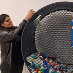 Mujer lanzando tapitas a un contenedor