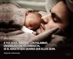 A man holding a sleeping a baby.