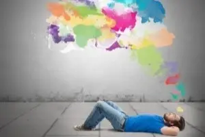 Persona acostada en el piso soñando con nube de colores