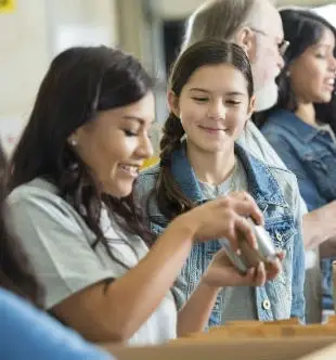 Two young girls observe an object.