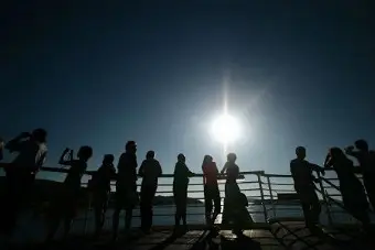 A group of people standing by a rail.