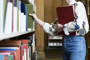 volunteer shelves books at library