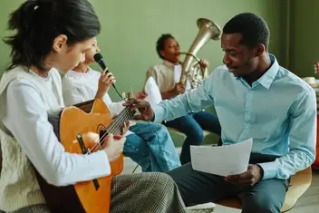 Young Black volunteer teaches music to students
