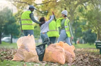 Volunteers high-five a child for cleaning up the park