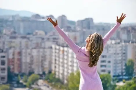 Mujer contenta levantando los brazos