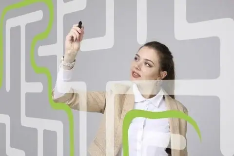 Mujer dibujando dentro de un laberinto en la pared