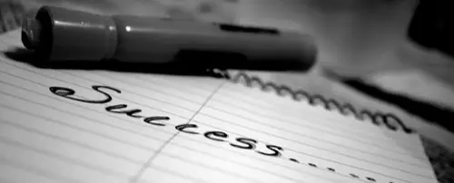 A notebook with 'Success' written on it.