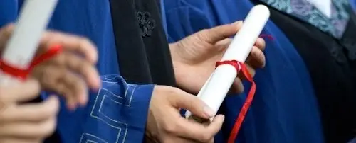 A close up of people graduating, with diplomas.