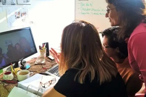 Tres compañeras mirando algo en el computador