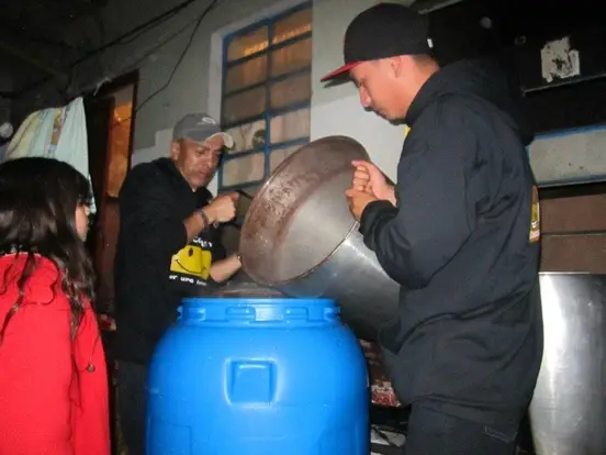 Men pouring into a large container