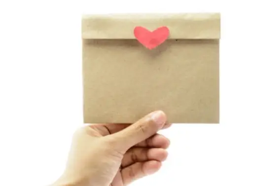 Una mano sosteniendo un sobre con un corazón