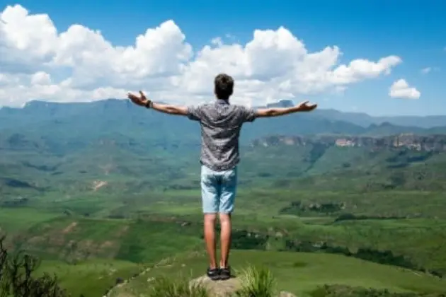 Persona en un espacio abierto en el campo abriendo los brazos