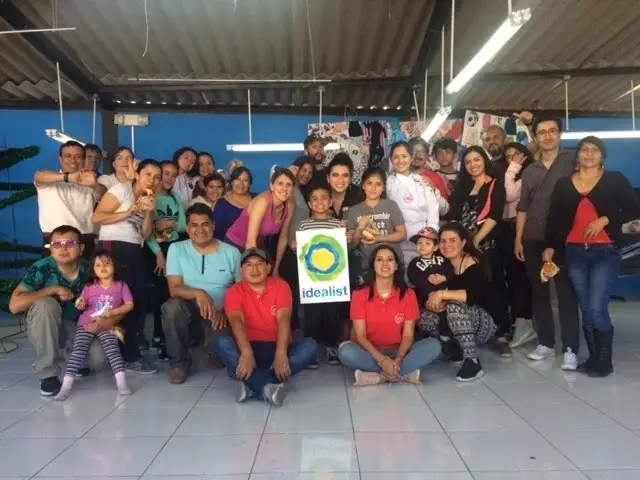 Group of people holding up a sign with the idealist logo.