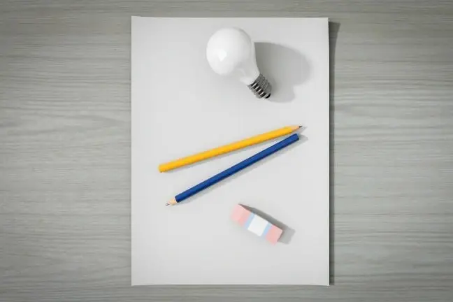 Una hoja de papel con unos lápices, una bombilla de luz y un borrador