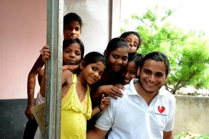 Un voluntario con varios niños con él