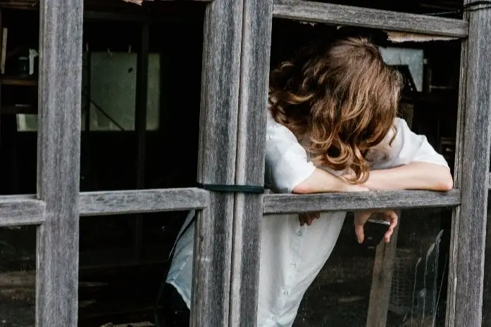 Mujer preocupada mirando por la ventana