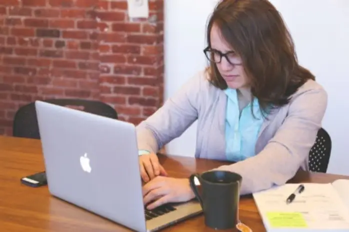 Mujer fruncida mirando pantalla de computador