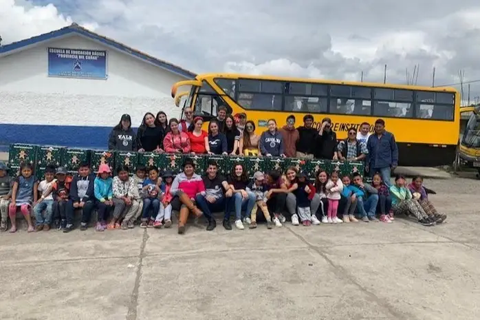 Un grupo de chicos frente a un bus escolar