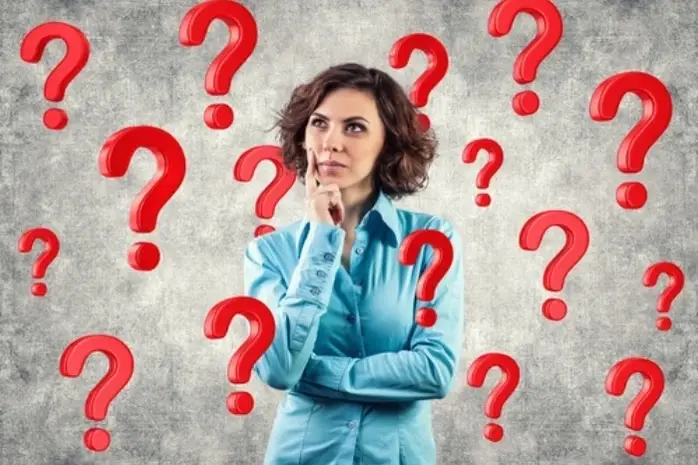Una mujer pensativa con varios signos de interrogación
