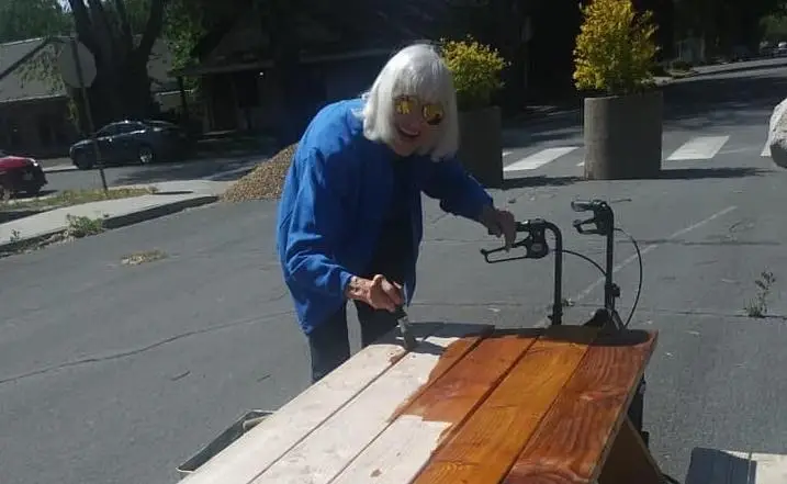 A woman smiling and painting.