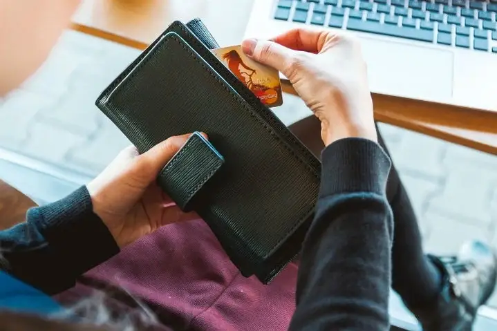 Persona sacando dinero de un monedero