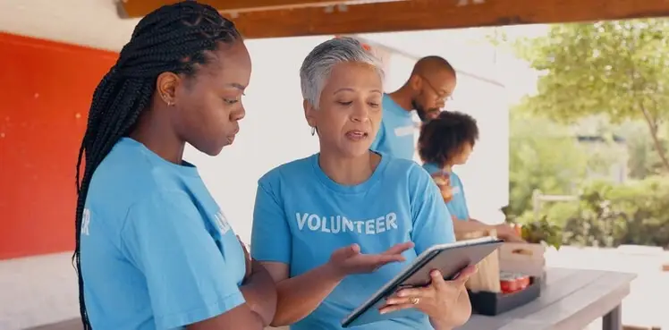 volunteers look at a clipboard of volunteer shifts