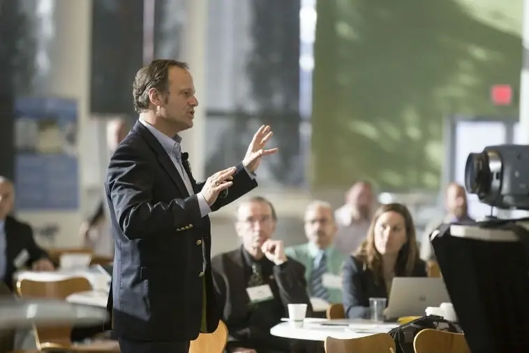 Un señor dando una charla a un equipo