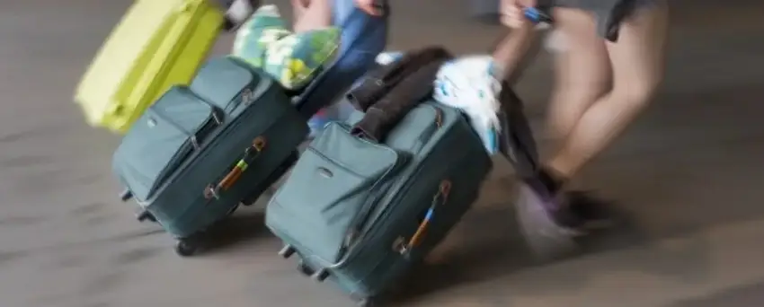 Malas com rodinha sendo arrastadas por pessoas jovens